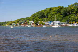 inland waterway with trees, cottages and boats docked